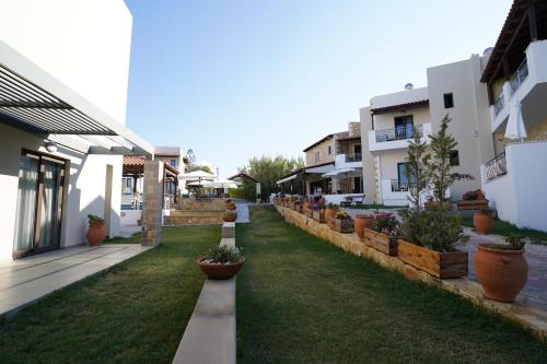 a row of houses with potted plants in a yard at Ledra Maleme Hotel in Maleme
