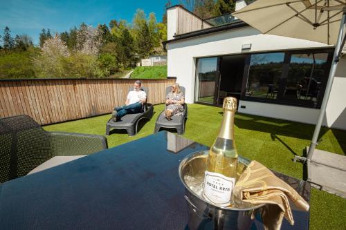 a bottle of champagne sitting on a table in a yard at Hotel Kras in Jedovnice