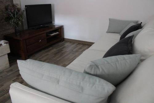 un salon avec un canapé blanc et une télévision dans l'établissement Can Jiz, à Figueres