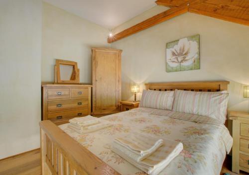 a bedroom with a large bed with two towels on it at Threshing Barn in Bampton