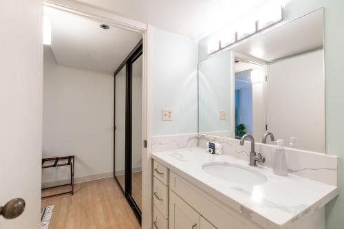 a bathroom with a sink and a mirror at Spacious Downtown Executive Retreat - Free Parking in Honolulu