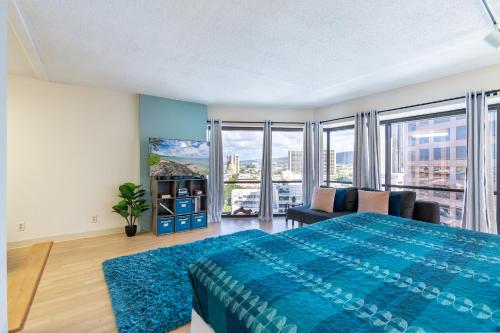 a bedroom with a large blue bed and a couch at Spacious Downtown Executive Retreat - Free Parking in Honolulu