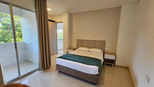 a bedroom with a bed and a large window at Hotel Santa Sofia in Puerto Salgar