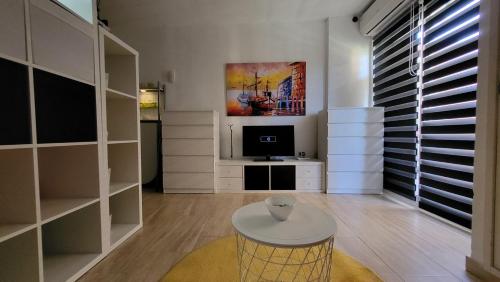 a living room with a table and a tv at Minerva 242 in Benalmádena