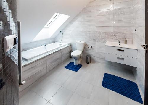 La salle de bains est pourvue de toilettes, d'une baignoire et d'un lavabo. dans l'établissement Moody Hostel, à Mława