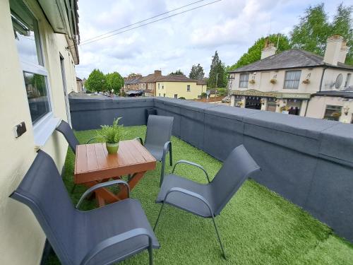 a patio with a table and chairs on a balcony at Bright 3 Bed Apartment With Terrace, Free Parking On Premises in Watford