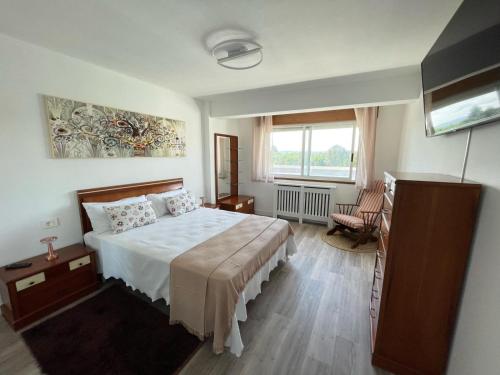 Un dormitorio con una cama grande y una ventana en Milladoiro, en Teo