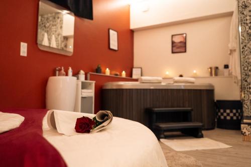 une chambre d'hôtel dotée d'un lit avec une rose. dans l'établissement Ignite Love Room, à Nantes