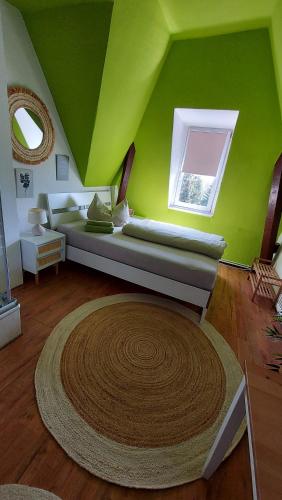 une chambre verte avec un canapé et une fenêtre dans l'établissement Villa Meuselwitz, à Meuselwitz