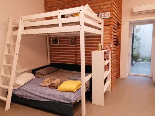 Ce lit superposé se trouve dans un dortoir avec une échelle. dans l'établissement Casa Al Vino, à Portici