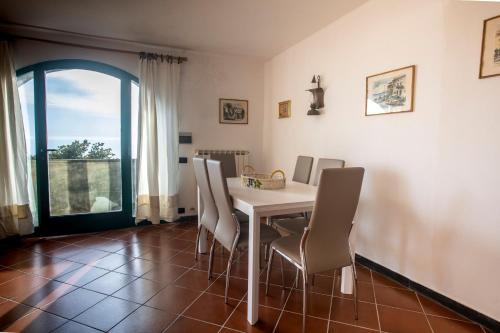 une salle à manger avec une table et des chaises blanches dans l'établissement 079 - La Villa storica Il Vigneto 45A, 7 minuti dal mare - Parcheggio privato GRATIS, à Moneglia