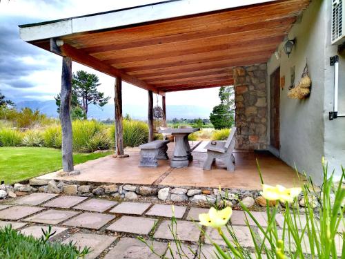 a patio with a wooden pergola and a picnic table at Fairfield Cottages in Ceres