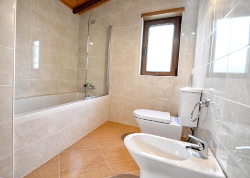 Un baño con inodoro, bañera y lavabo. en Spacious Villa in Celorico de Basto with Private Pool, en Celorico de Basto