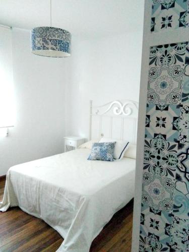 a bedroom with a white bed and a wall at 4 bedrooms appartement at Bueu in Bueu