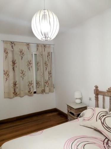 a bedroom with a bed and a chandelier at 4 bedrooms appartement at Bueu in Bueu
