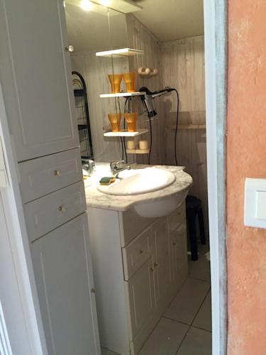 une salle de bain avec un lavabo et un miroir dans l'établissement Maison accueillante à Saint-Géry avec piscine partagée, à Saint-Géry