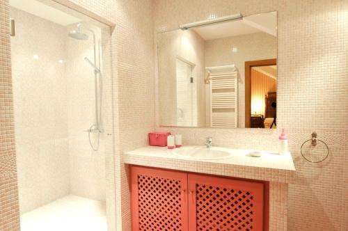 uma casa de banho com um lavatório, um chuveiro e um espelho. em 6 bedrooms villa with private pool furnished garden and wifi at Santo Tirso em Santo Tirso