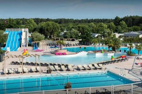 une grande piscine dans un complexe hôtelier avec des chaises et de l'eau dans l'établissement Bungalow charmant Gastes piscine privée, à Gastes