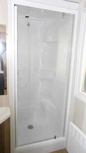 une douche avec une porte vitrée dans une salle de bain dans l'établissement Bungalow charmant Gastes piscine privée, à Gastes