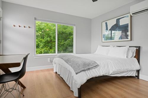 um quarto branco com uma cama, uma secretária e 2 janelas em Detached 1 Bed 1 Bath In-law Suite 3 miles from Downtown! em Austin