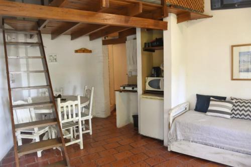 1 dormitorio con cama, mesa y cocina en Puerto Sosiego en Gualeguaychú