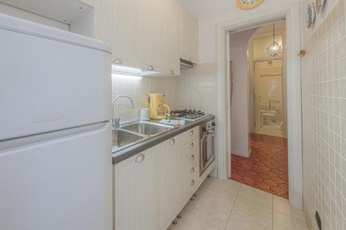 a kitchen with white cabinets and a sink and a tub at RAPALLO APARTMENT Comodo e in Ottima Posizione in Rapallo