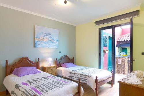 ポンタ・ド・ソルにある2 bedrooms house with sea view furnished terrace and wifi at Ponta do Sol 5 km away from the beachのベッドルーム1室(ベッド2台、窓付)