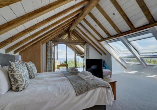 um quarto com uma cama grande num quarto com janelas em Whimbrels em Berrynarbor