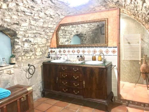 a stone bathroom with two sinks and a mirror at 2 bedrooms villa with private pool enclosed garden and wifi at Castellbell i el Vilar in San Vicente de Castellet