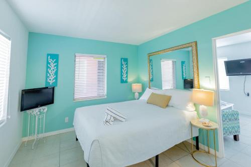 a bedroom with a large bed and a tv at Cabanas of Treasure Island in St. Pete Beach