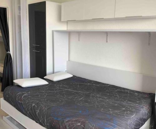 un lit avec deux oreillers dessus dans une chambre dans l'établissement studio tout équipé place de parking centre port, au Cap d'Agde