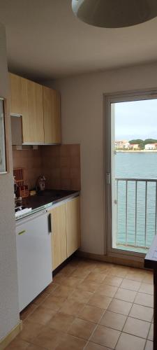 une cuisine avec vue sur l'eau et une fenêtre. dans l'établissement Ancre et Mouettes, à Saint-Cyprien