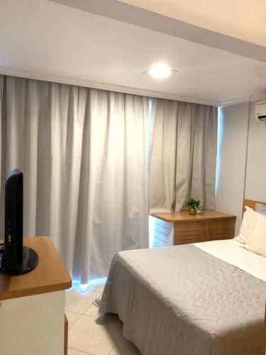 a bedroom with a bed and a window with curtains at Apart Hotel Centro de Brasília (Garvey Park Hotel) in Brasilia