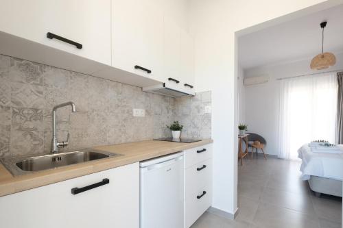 een keuken met witte kasten en een wastafel bij Casa Campos Arillas in Arillas