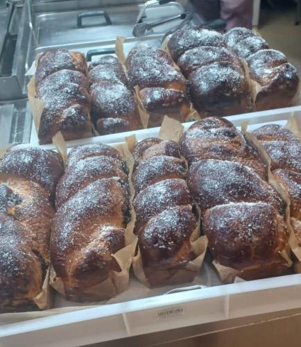 a display case of donuts with powdered sugar on them at Hotel Ieremia Movila in Suceviţa