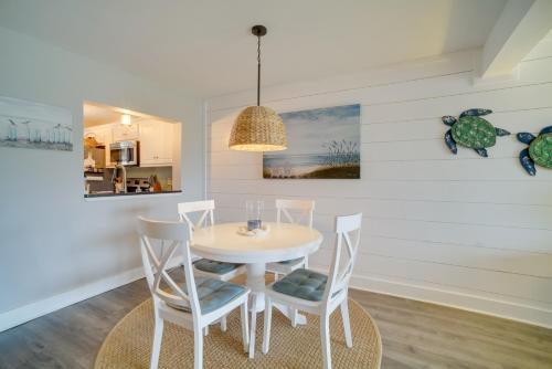 a dining room with a white table and chairs at Beachfront Condo with 3 Pools on St Helena Island! in Oceanmarsh Subdivision