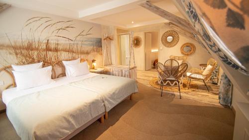 a bedroom with a bed and a table and chairs at Hotel Beaucour in Strasbourg