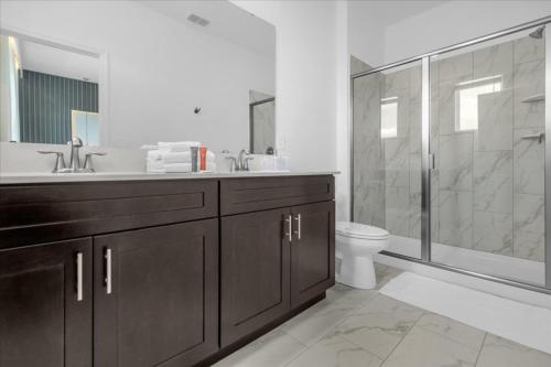 uma casa de banho com um lavatório, um WC e um chuveiro em 6 Bedrooms 5 Bathrooms Storey Lake 4370 Rs em Kissimmee