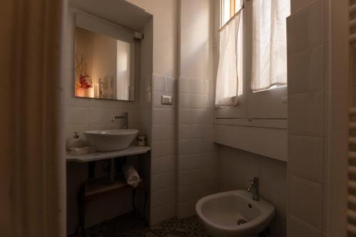 a bathroom with a sink and a toilet and a mirror at Antica Dimora dei Nonni in Lecce