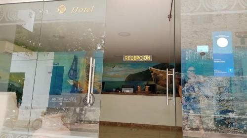 a glass door with a hotel sign in a store at Hotel Tayromar in Santa Marta