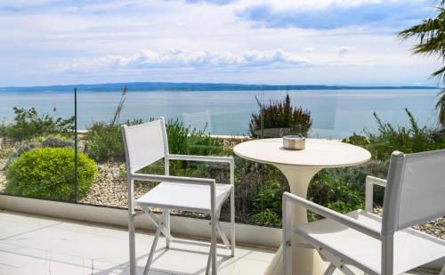 a patio with a table and chairs and a view of the water at Gallery Luxury Suites & Rooms-Only Adults in Split