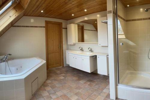 y baño con bañera, 2 lavabos y ducha. en La Villa des Vennes en Heure