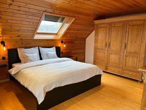 1 dormitorio con 1 cama grande y paredes de madera en La Villa des Vennes en Heure