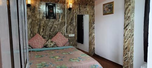 a bedroom with a bed and a stone wall at Tea corner Guest house in Darjeeling
