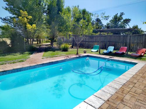 uma piscina com duas cadeiras e uma cerca em Fairfield Cottages em Ceres
