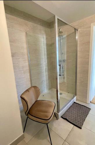 ducha con silla y cabina de ducha acristalada en Stunning private room to visit Paris en París