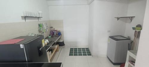 uma cozinha com um frigorífico preto e piso em azulejo verde em Apartamento con 2 Habitaciónes 