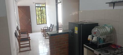 a kitchen with a black refrigerator in a room with chairs at Apartamento con 2 Habitaciónes 