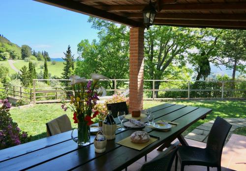 una mesa de madera con flores en el patio en Chalet Elena in Montescudaio, ground floor with fenced garden, en Montescudaio