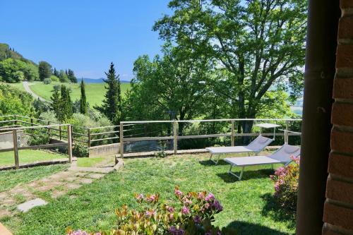 un giardino con due sedie e una recinzione di Chalet Elena in Montescudaio, ground floor with fenced garden a Montescudaio